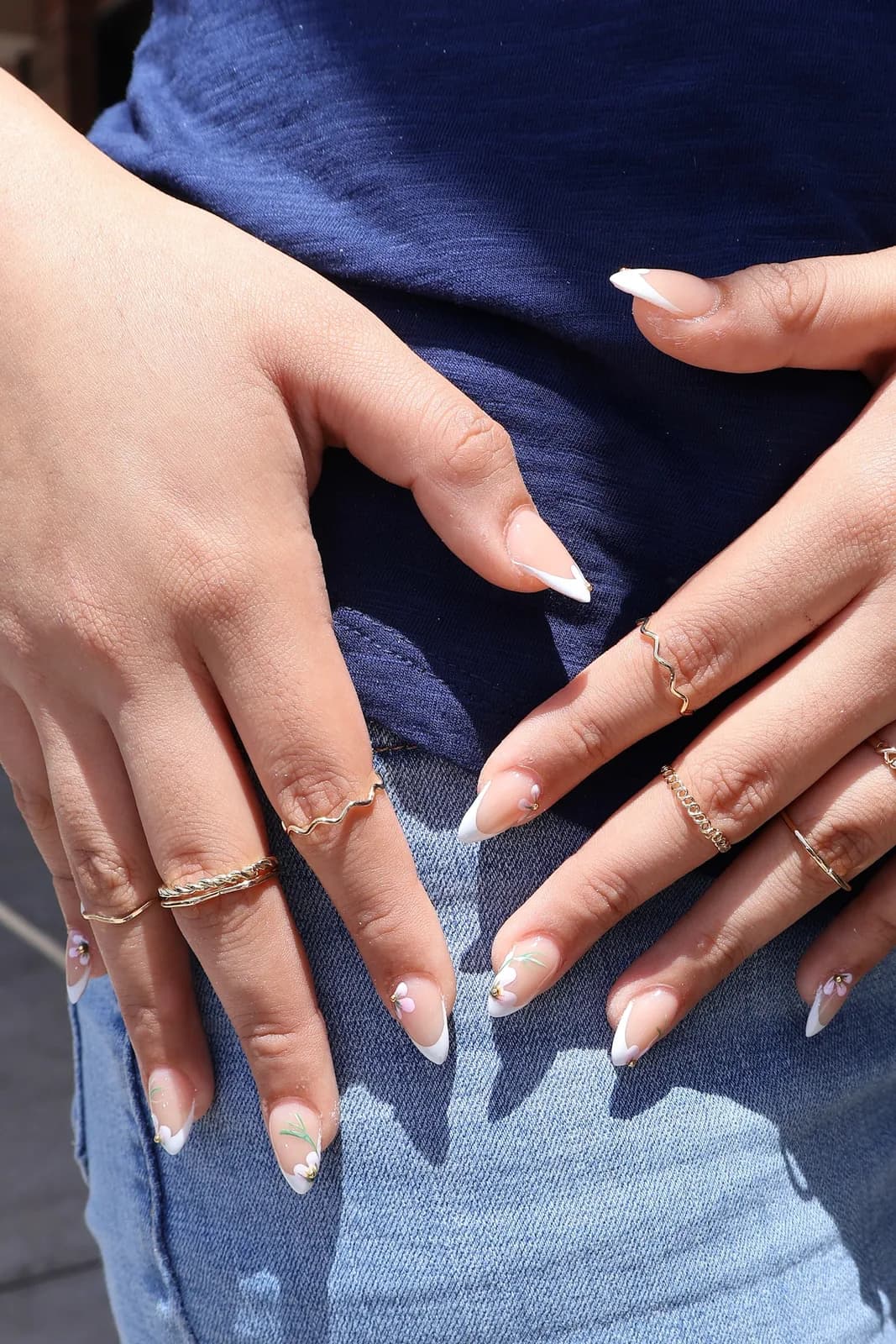 Natural-length French manicure photographed outdoors on denim